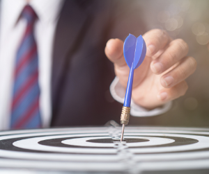 Man in suit with dart on bullseye